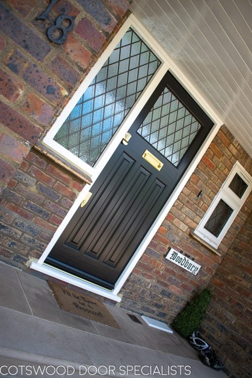 Black 1930s front door with leaded glass. Glazed door frame with diamond leaded glass. Brass door furniture