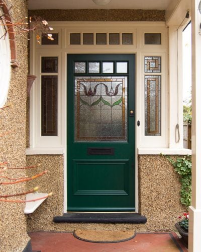 Edwardian front entrance with decorative frame. Stained glass to the door and frame. Door painted dark green. Edwardian porch