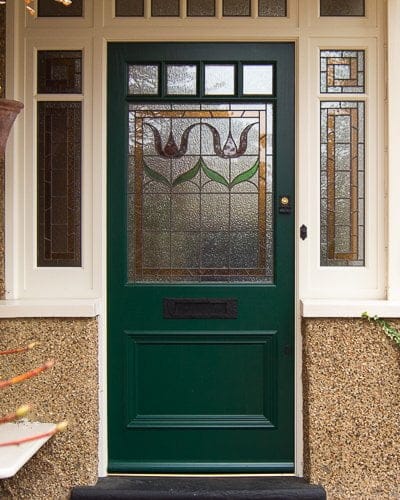 Edwardian front entrance with decorative frame. Stained glass to the door and frame. Door painted dark green. Edwardian porch