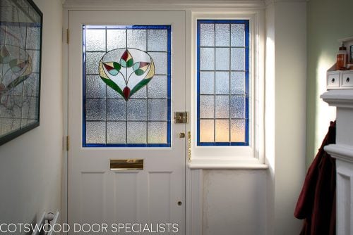 Late Edwardian red front door and sidelight frame. Shot from hallway of stained glass