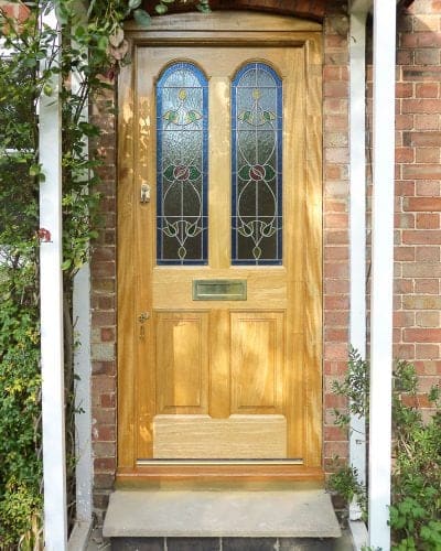 Natural wooden Victorian cottage front door with stained glass