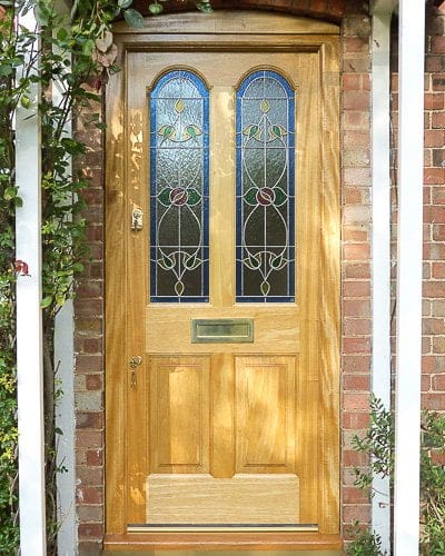 Natural wooden Victorian cottage front door with stained glass