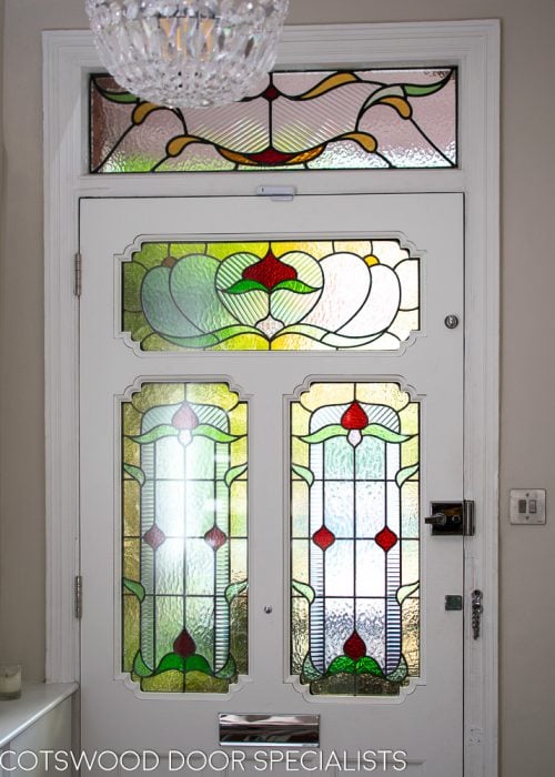 Ornate Edwardian front door stained glass. Door painted dark green inside painted white. View from hallway