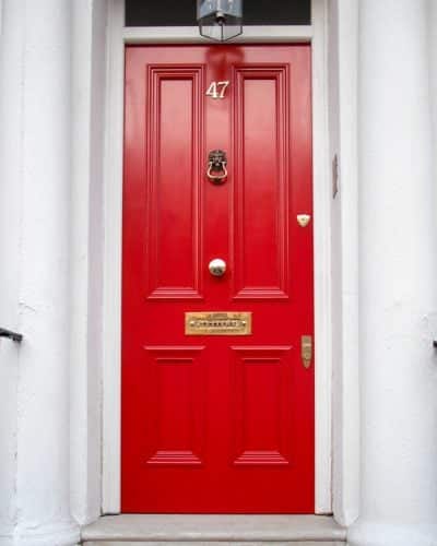 bright red Victorian London door with brass furniture