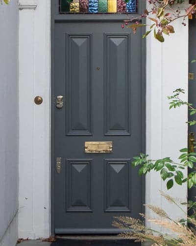 Dark grey Victorian front door solid with no glass. Stained glass to door frame
