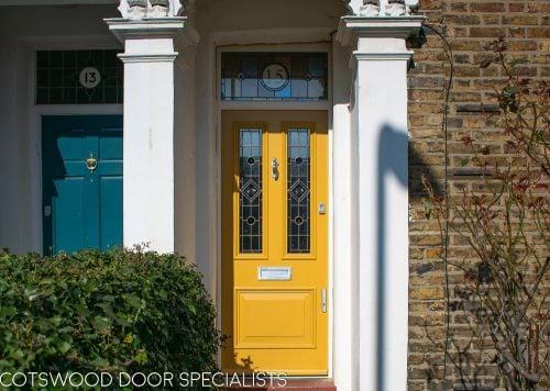 painted yellow Victorian front entrance door and frame with stained glass. Number in glass above door