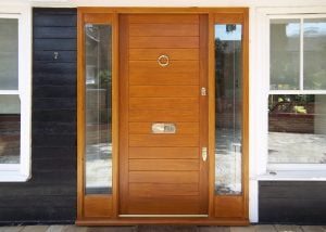 contemporary wooden front door and sidelight frame. Clear glass and polished chrome door furniture