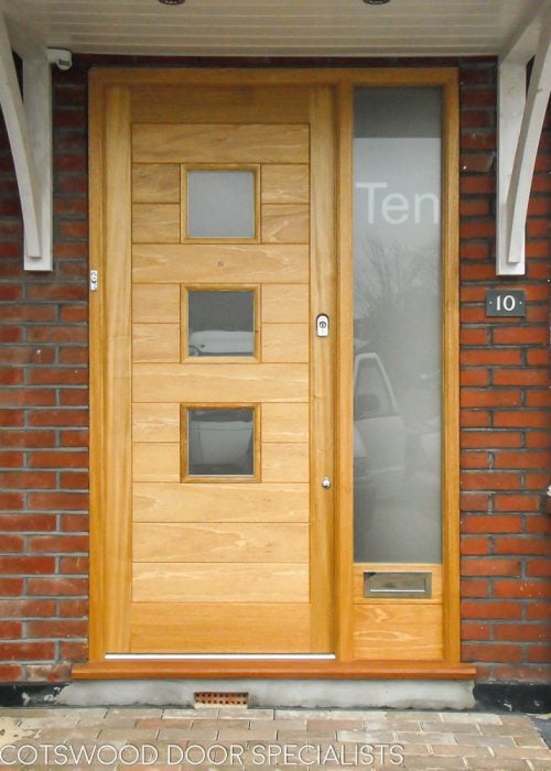 Contemporary glazed front door and sidelight frame. Etched glass in frame with number. Light stained natural wood
