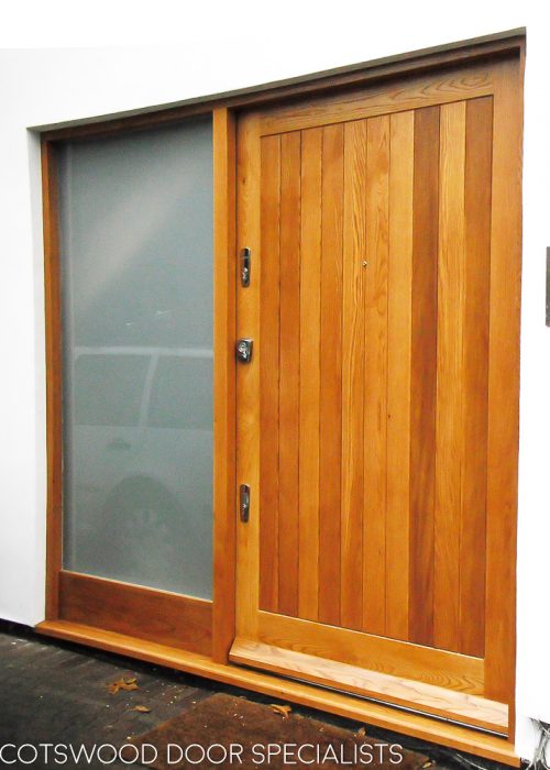 Extra wide contemporary front door. Light stained natural wood. Polished chrome door furniture. Sidelight frame fitted with satin etched glass