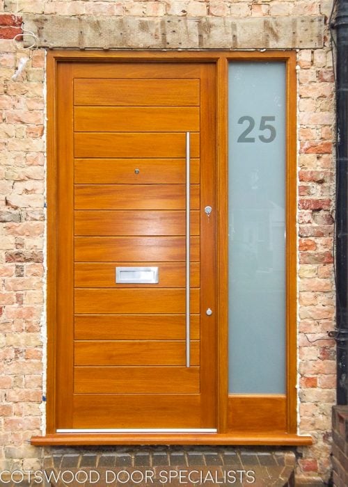 Modern wooden door and sidelight frame. Solid door with horizontal boards. Etched glass in sidelight with clear number. Satin chrome door furniture with long bar handle.