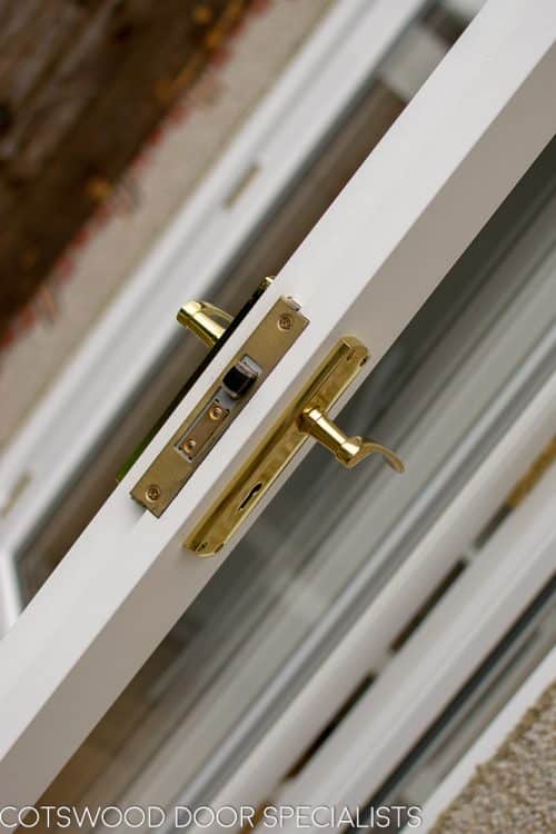 Brass door handle on wooden french doors. Lock closeup