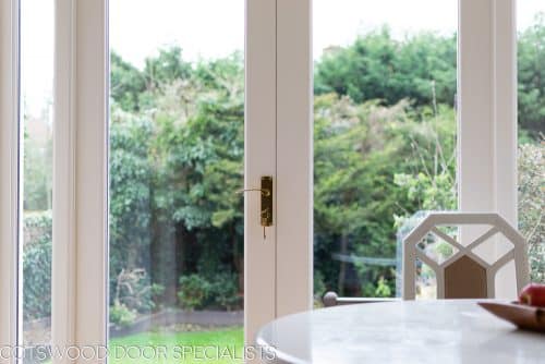 White painted wooden glazed french door with sidelight frame. Double glazed clear glass and brass hardware