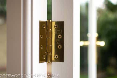 Brass door hinge on wooden french doors