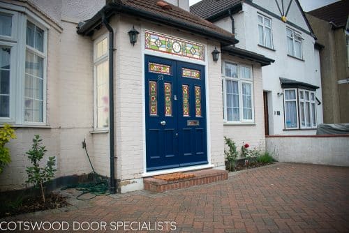 Victorian double doors with stained and leaded glass. Doors are painted dark blue with Teknos spray paint, finish is beautiful. Intricate stained glass design to the doors and the frame. The new door frame has the number above the doors incorporated in the stained glass.