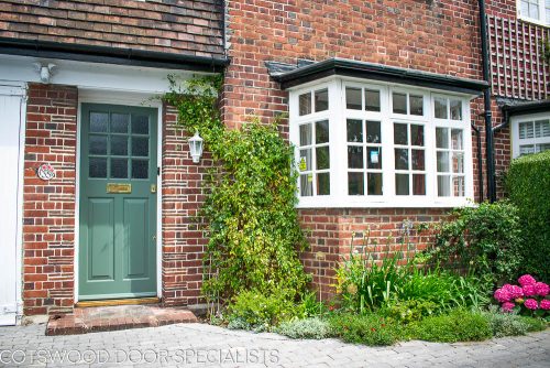 1920s 9 light front door with 2 panels. Door fitted into a London home. Glass divided with wooden glazing bar into 9 pieces. Glass textured and obscured with 9 double glazed units. Painted in a classic light green colour. Brass door furniture