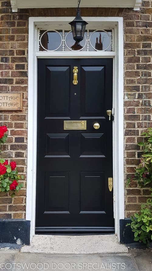 Georgian raised panelled door with fanlight painted black. polished brass furniture. fitted in London into existing frame. decorative Georgian fanlight with metal glazing.