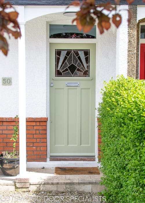 Stained glass 1930's Door. Stained glass with a geometric art deco pattern. Different colours of glass combined with different textures highlight the design. Door painted light green in colour. Satin chrome door fittings. Wooden door frame has a clear piece of glass.
