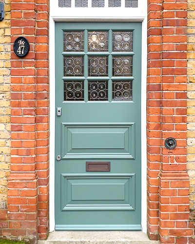 Edwardian style front door with bullion leaded glass. Decorative 9 pane Edwardian style front door fitted into a wooden frame in London. Paint finish in green with a white door frame. Door made in Accoya wood.