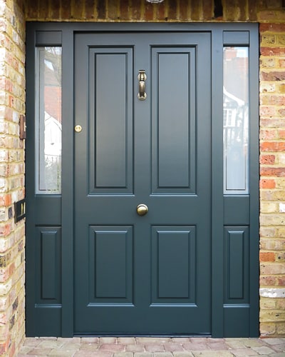 Raised panelled solid Victorian front door and new frame. Bespoke traditional door fitted into an open porch surrounded by oak beams. New door is painted dark green and the frame is also dark green. High security multi point locking system. Antique brass door furniture fitted with a Doctor knocker and a door knob