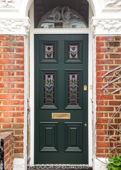 Stained glass Georgian front door fitted in London. Decorative door frame with dental block to transom. Original stained glass design with flowers. Door painted dark green with brass door furniture