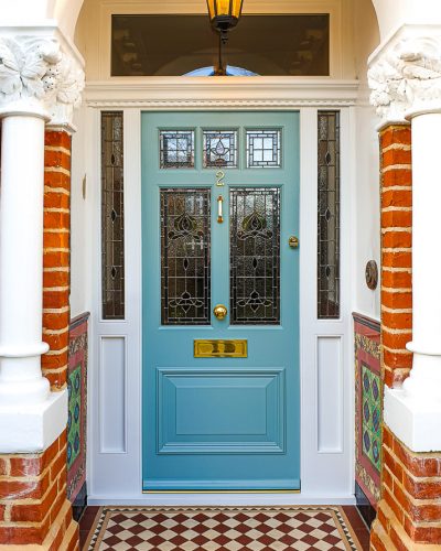 Victorian external door fitted with a new decorative door frame. Traditional stained glass made as double glazed units. Painted door and frame. Door furniture. Wide Victorian open porch with Victorian style tiles
