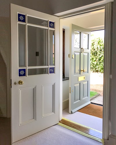 Victorian vestibule internal front door with wooden glazing bar. The door has brilliant cut glass glory stars on blue glass. Other glass is clear bevelled glass. Brass Georgian style door knob. Fully painted white