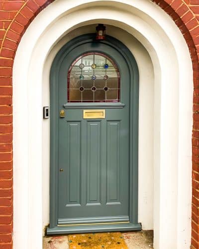 Arched 1930s front door with an arched glass panel featuring rondels.