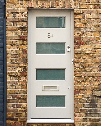 Contemporary London front door. Painted front door with etched glass fitted into old London home with yellow brick. Satin chrome security locks