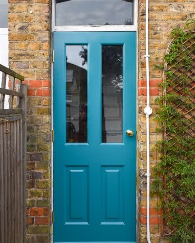 Painted Victorian back door. Door is painted a bright blue green colour. Clear glass and brass door hardware.