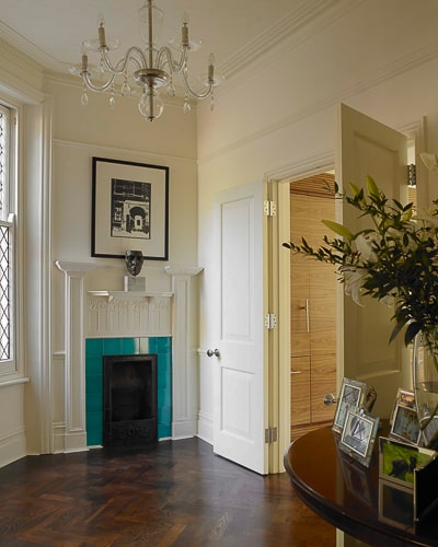 Painted raised panel internal doors fitted in an Edwardian hallway. Hallway has art nouveaux fireplace