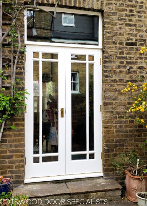 Victorian fully glazed french door with glory star . French door pair set into Victorian yellow stock brickwork. Wooden doors are painted white. Glass is double glazed with glory star red corners.