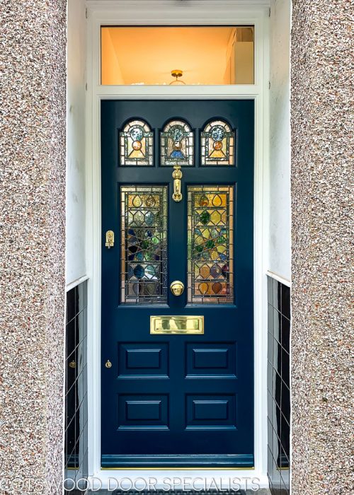 Midnight blue Victorian front door featuring colourful Moorish stained glass and brass door furniture