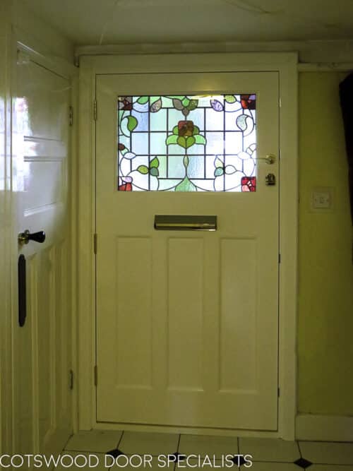 1920s Stained glass door. Simple 1920s door with rectangular stained glass fitted into a London home. Replica stained glass made as double glazed unit. Multipoint locking fitted to a wooden door. Brassart door furniture. Hallway shot showing off 1920s stained glass and wooden door