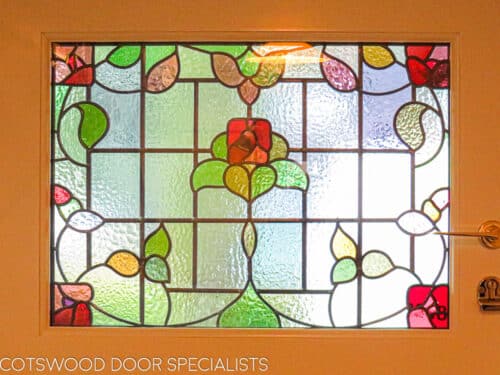 1920s Stained glass door. Simple 1920s door with rectangular stained glass fitted into a London home. Replica stained glass made as double glazed unit. Multipoint locking fitted to a wooden door. Brassart door furniture. Internal shot of stained glass
