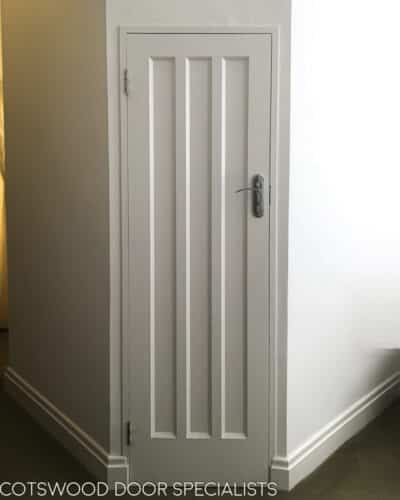 Art Deco 1930s internal door. Fully painted white and fitted with chrome door handle. Fitted into a london home. Row of three long vertical panels of art deco design to door