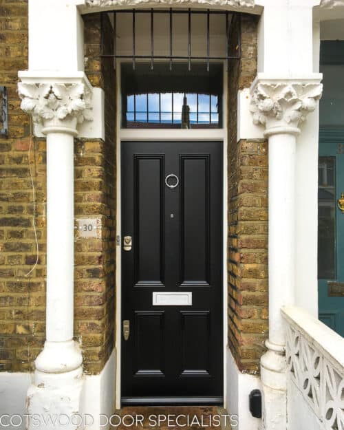 Black Victorian front door. Classic Victorian front door fitted into a Victorian London terraced house with yellow stock brickwork. Flat panels to door with inset panel mouldings giving a decorative but minimalist look. black paint to door, white to door frame