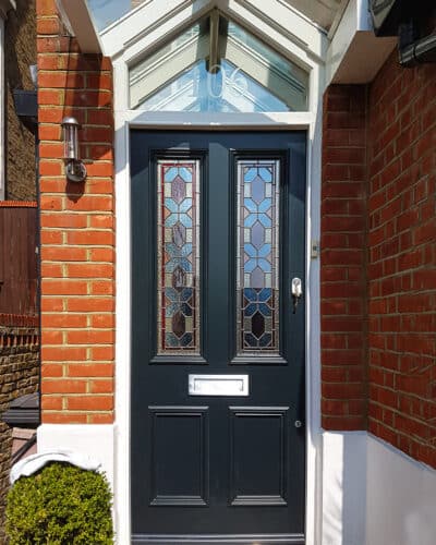 Blue Victorian door door has geometric stained glass . 2 Panels of stained glass in a classic Victorian front door. Different textures and colours in the stained glass. Door frame has an double raked head and is fitted with sandblasted glass with a number. Satin chrome door furniture