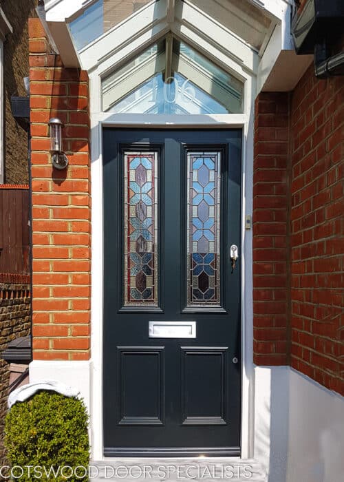 Blue Victorian door door has geometric stained glass . 2 Panels of stained glass in a classic Victorian front door. Different textures and colours in the stained glass. Door frame has an double raked head and is fitted with sandblasted glass with a number. Satin chrome door furniture