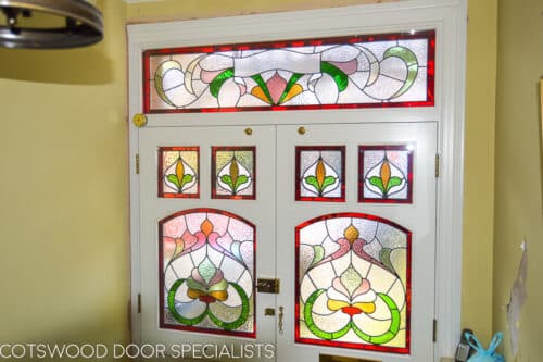 Edwardian stained glass doors. Pair of Edwardian front doors with an ornate stained glass design. Doors fitted into open porch with decorative roof. Red brick surrounding painted light blue doors. Antique brass door furniture. Period stained glass replicating original Edwardian design. Hallway shot of Edwardian stained glass
