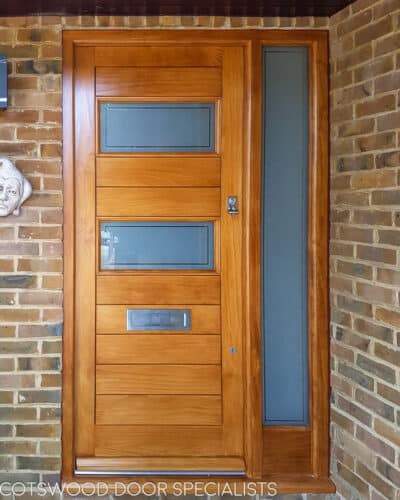 Modern stained wooden door. Beautiful grain to Accoya wooden front door. Door has glazing and a side panel of glass