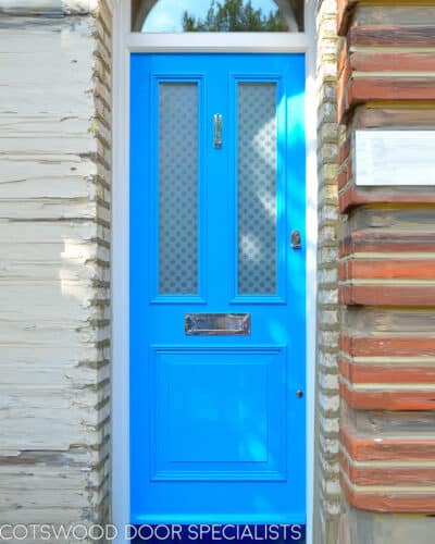 Tall Blue Victorian door. An extra tall Victorian door painted light blue. Fitted into a North London terraced home. Etched glass with a repeated pattern. Polished chrome door furniture.