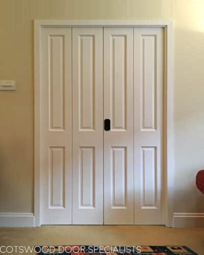 bifolding victorian internal doors. Set of room dividing bifolding Victorian style wooden door painted white. Doors hung on hinges with no need for track