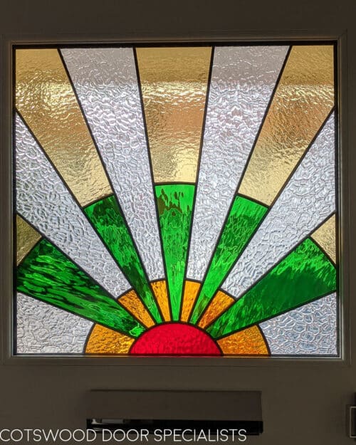 1930s sunburst stained glass hallway photo. Yellow, green and red glass