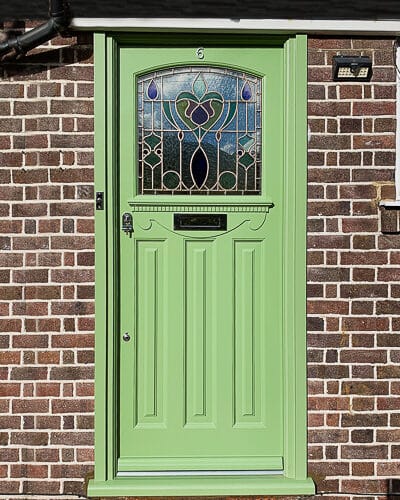 Art Nouveau style 1920s door. Art nouveau stained glass fitted into a 1930s front door. Door has some Edwardian features like a very decorative shelf with dental block and scrolled apron