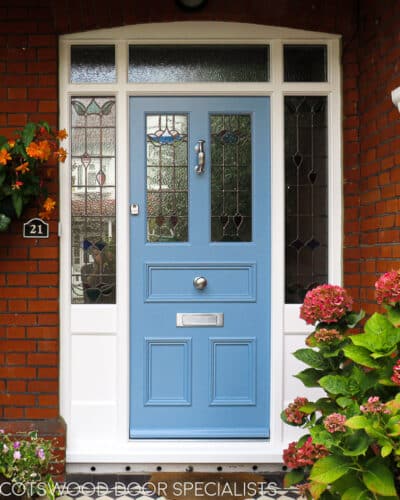 Blue Edwardian Entrance door. Large Edwardian front entrance with central door and double sidelight and fanlight frame. Door and frame have complimentary stained glass. Wooden door is painted blue and frame white. Fitted into a London red brick home