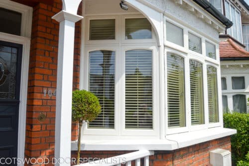 Edwardian bay windows. Edwardian london home with 3 casement bay windows in white painted wood. Window have decorative curved glass. Opening windows have locking system and are all fully double glazed. Closeup of ground floor bay