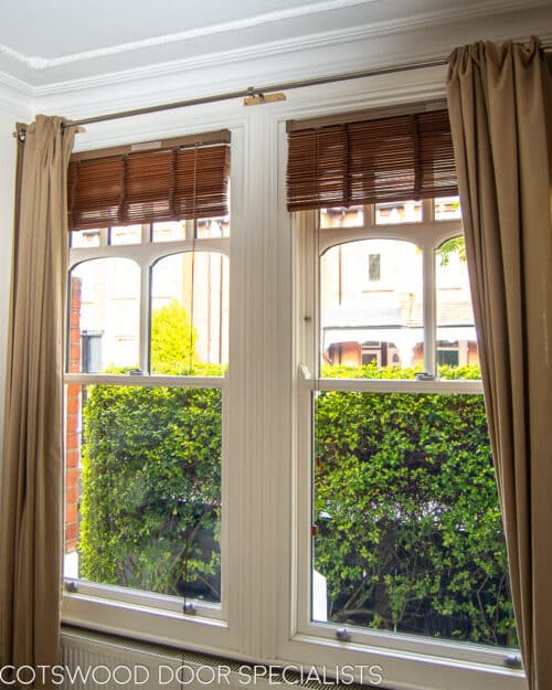 Edwardian sash window. Decorative Edwardian sash window with multiple shaped panes of glass. Glazing is a double glazed. Wooden window is painted white and fitted into a red brick London home