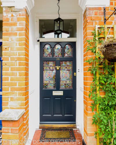 Five light Victorian door . Victorian front door with 5 pieces of geometric stained glass. Door has brass door furniture and is fitted with a bee door knocker