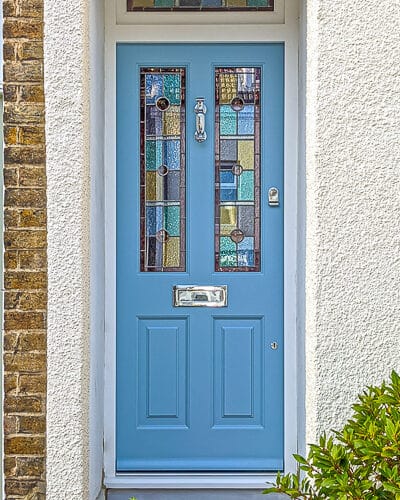 Opening fanlight Victorian door. Victorian front door with stained glass, door painted light blue. Door frame has an opening fanlight. Geometric stained glass design