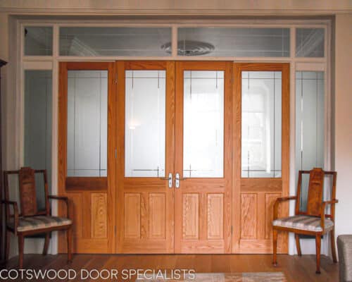 Room dividing period doors. Large screen comprising of stained oak doors and a painted wooden glazed frame. The glass in the doors and frame is sandblasted leaving a line detail. The doors fold back on hinges